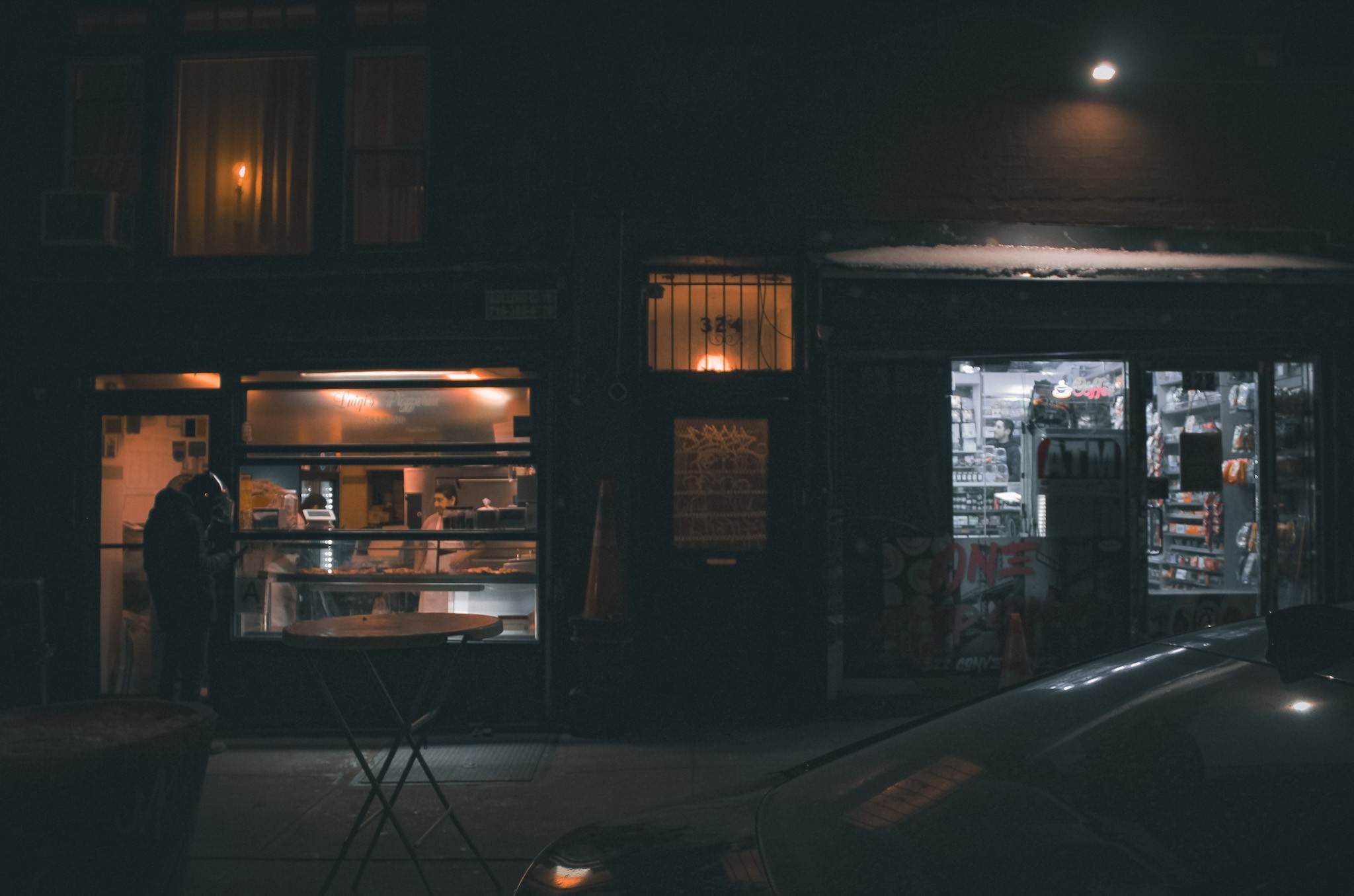Neighborhood storefronts at night — photograph by Tony Powers