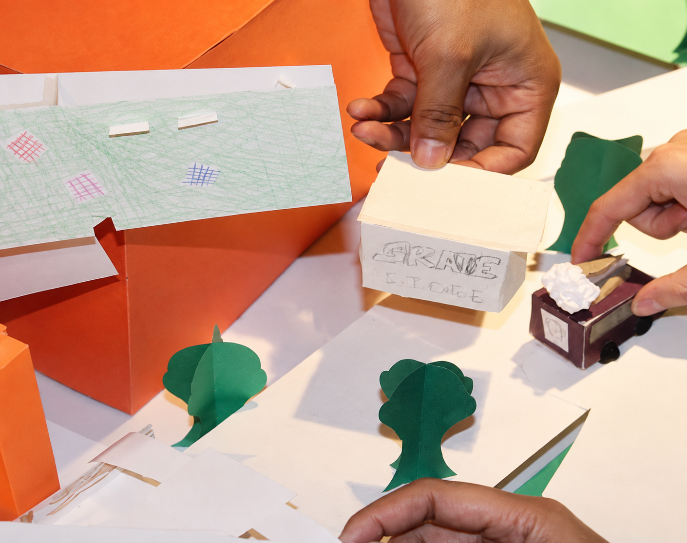 Hands assembling a student architectural model — Reading the Block mentorship